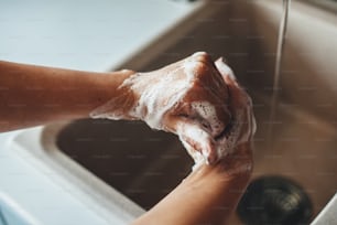 Vista dall'alto foto di una procedura di lavaggio delle mani con sapone a casa durante la situazione pandemica
