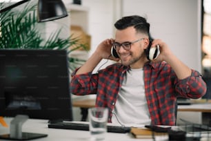 Handsome businessman listening the music while working in the office. Young man working in the office.