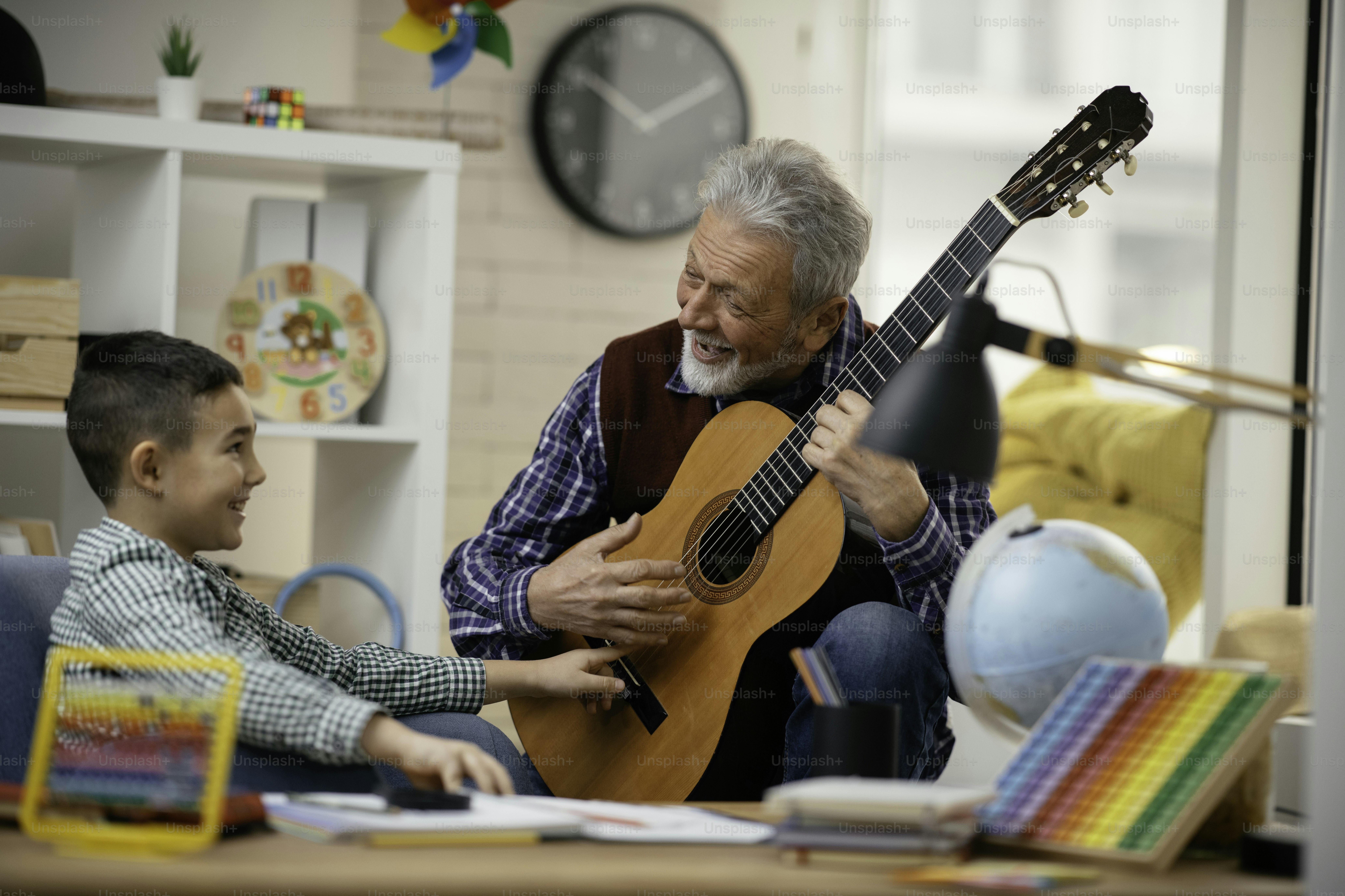 Grandfather and grandson playing guitar. Grandfather and grandson enjoying at home