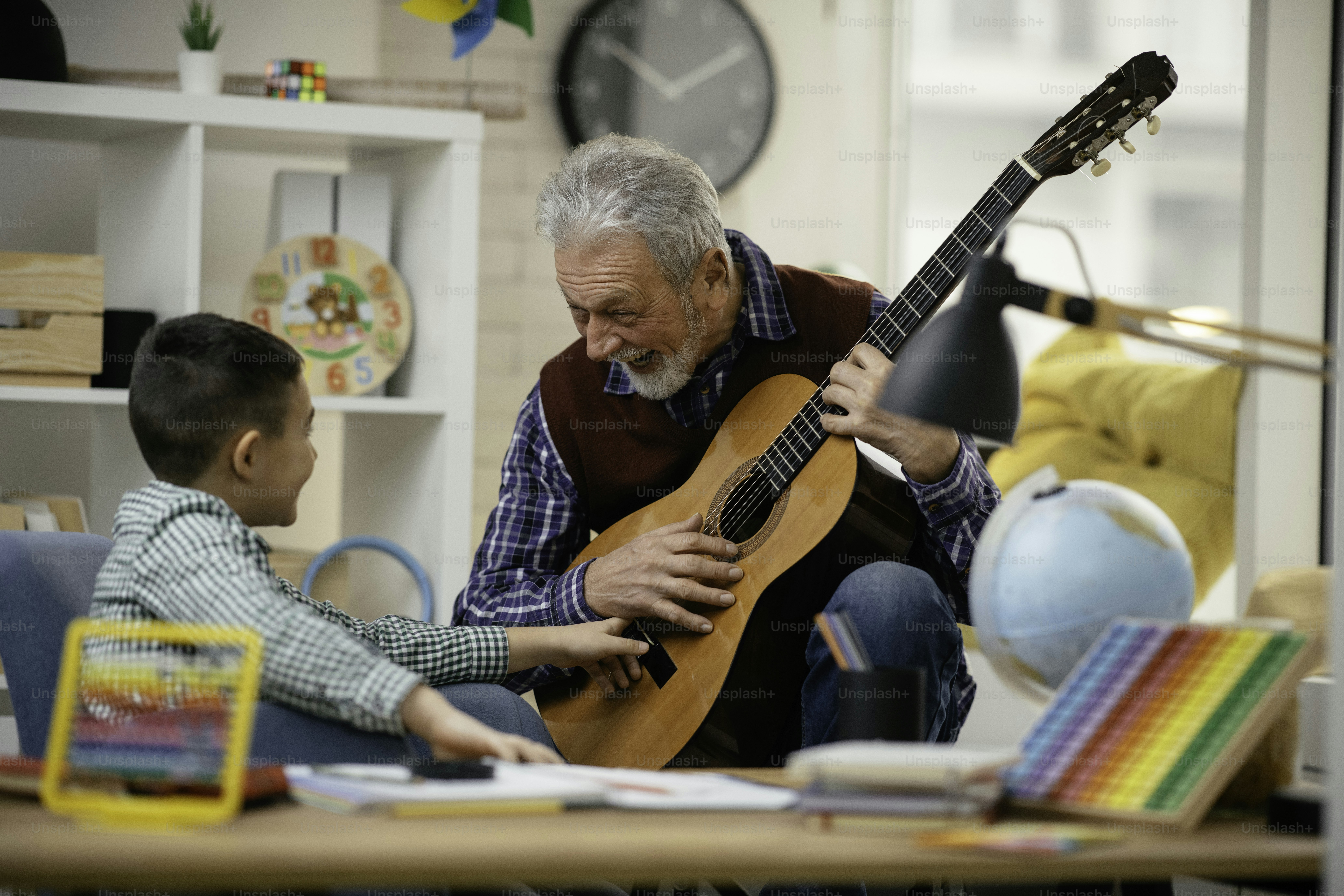 Grandfather and grandson playing guitar. Grandfather and grandson enjoying at home