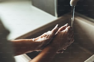 Foto de perto de um procedimento de lavagem das mãos com sabão durante a situação de pandemia