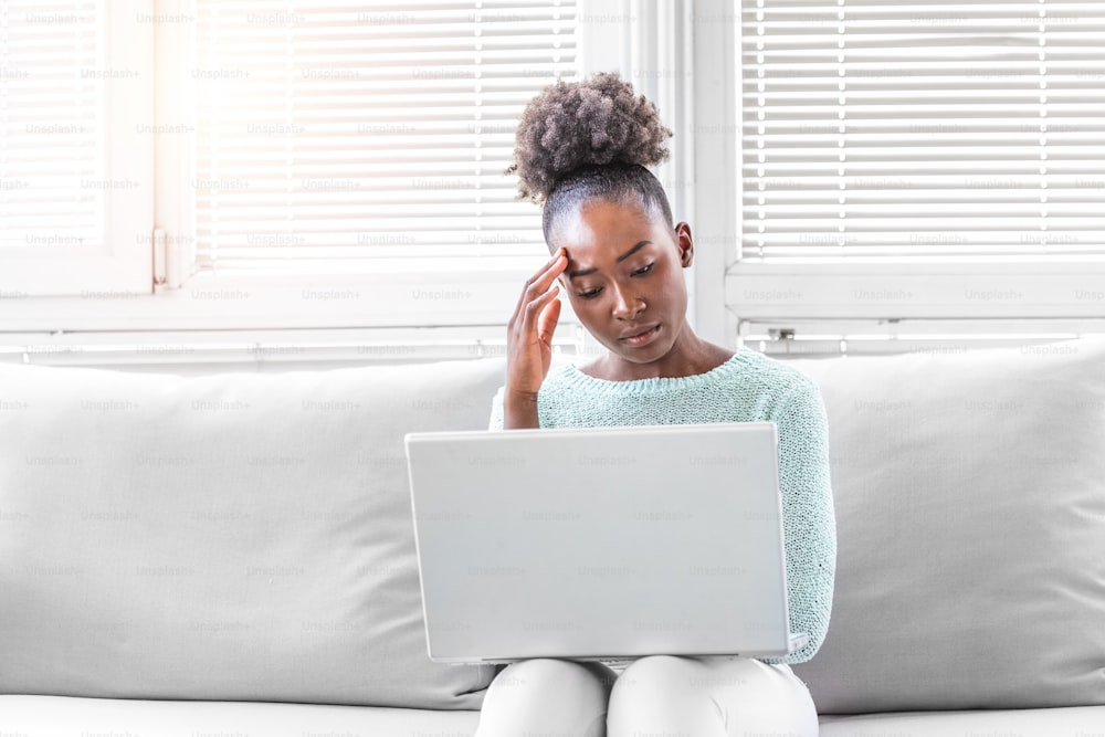 Young frustrated woman working in front of laptop suffering from chronic daily headaches, treatment online, appointing to a medical consultation, electromagnetic radiation, sick pay