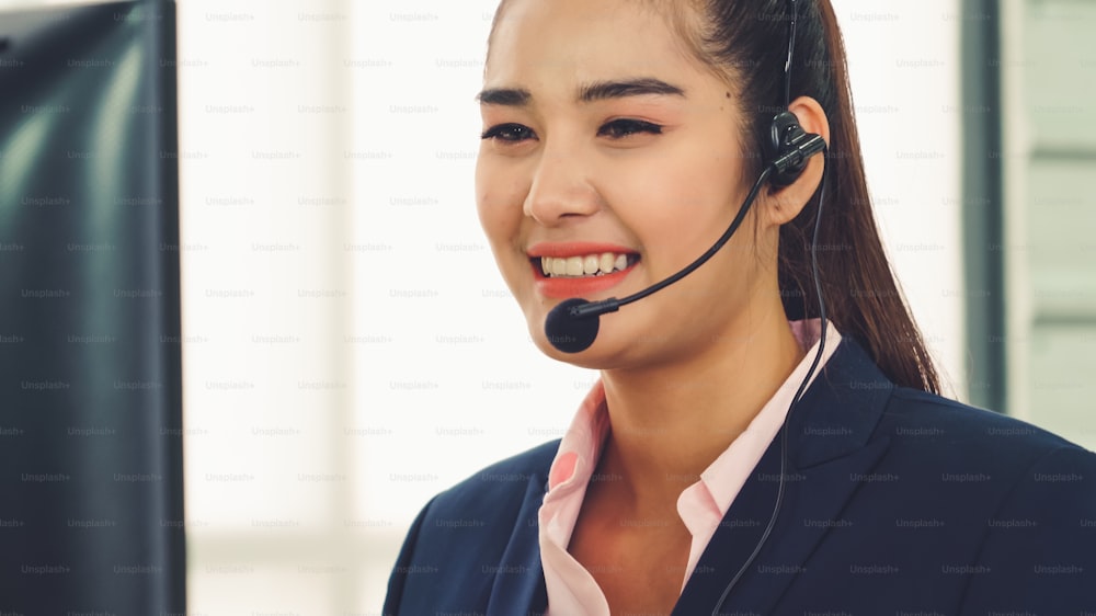 ヘッドセットを装着したビジネスマンがオフィスで作業し、リモートの顧客や同僚をサポートします。コールセンター、テレマーケティング、カスタマーサポートエージェントは、電話ビデオ会議通話でサービスを提供します。