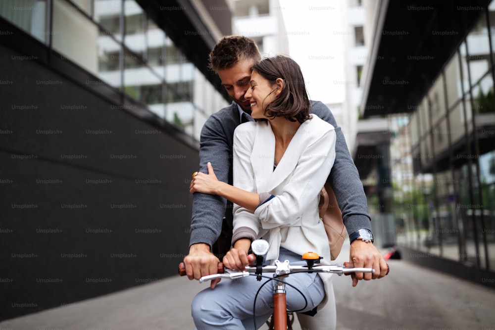 Retrato de una pareja joven feliz enamorada que monta en bicicleta y se divierte juntos al aire libre