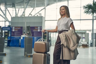 Pretty blonde woman demonstrating her smile while going to have business trip