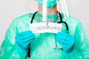 Concepto de cuarentena por coronavirus. Covid - 19. Nuevo coronavirus (2019-nCoV). Médico con estetoscopio Rasga el papel con la palabra coronavirus.