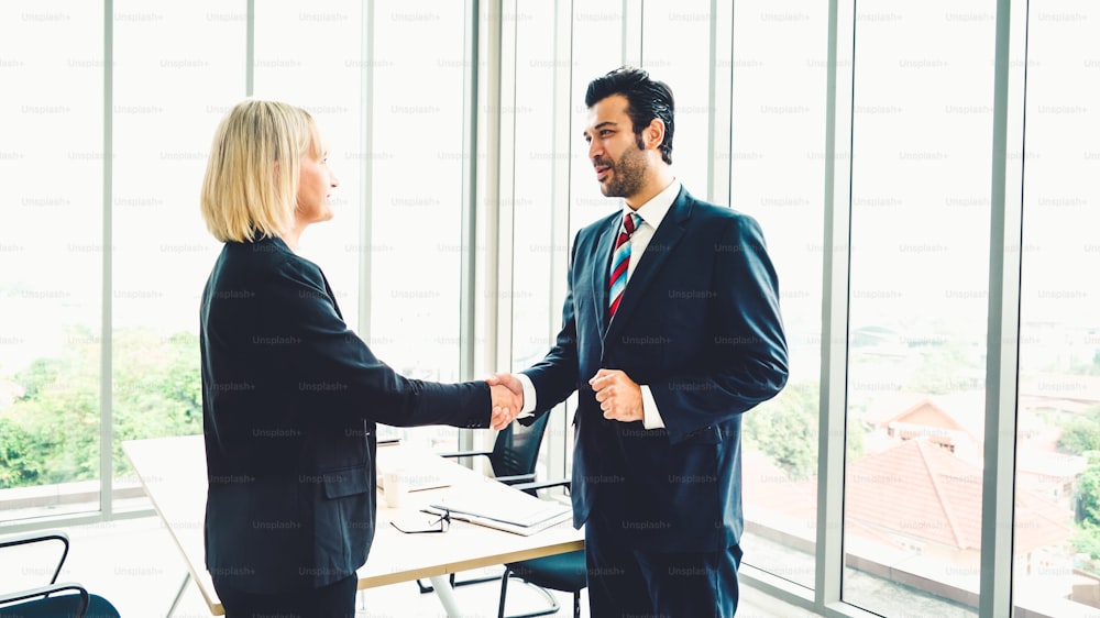 Business people handshake in corporate office showing professional agreement on a financial deal contract.