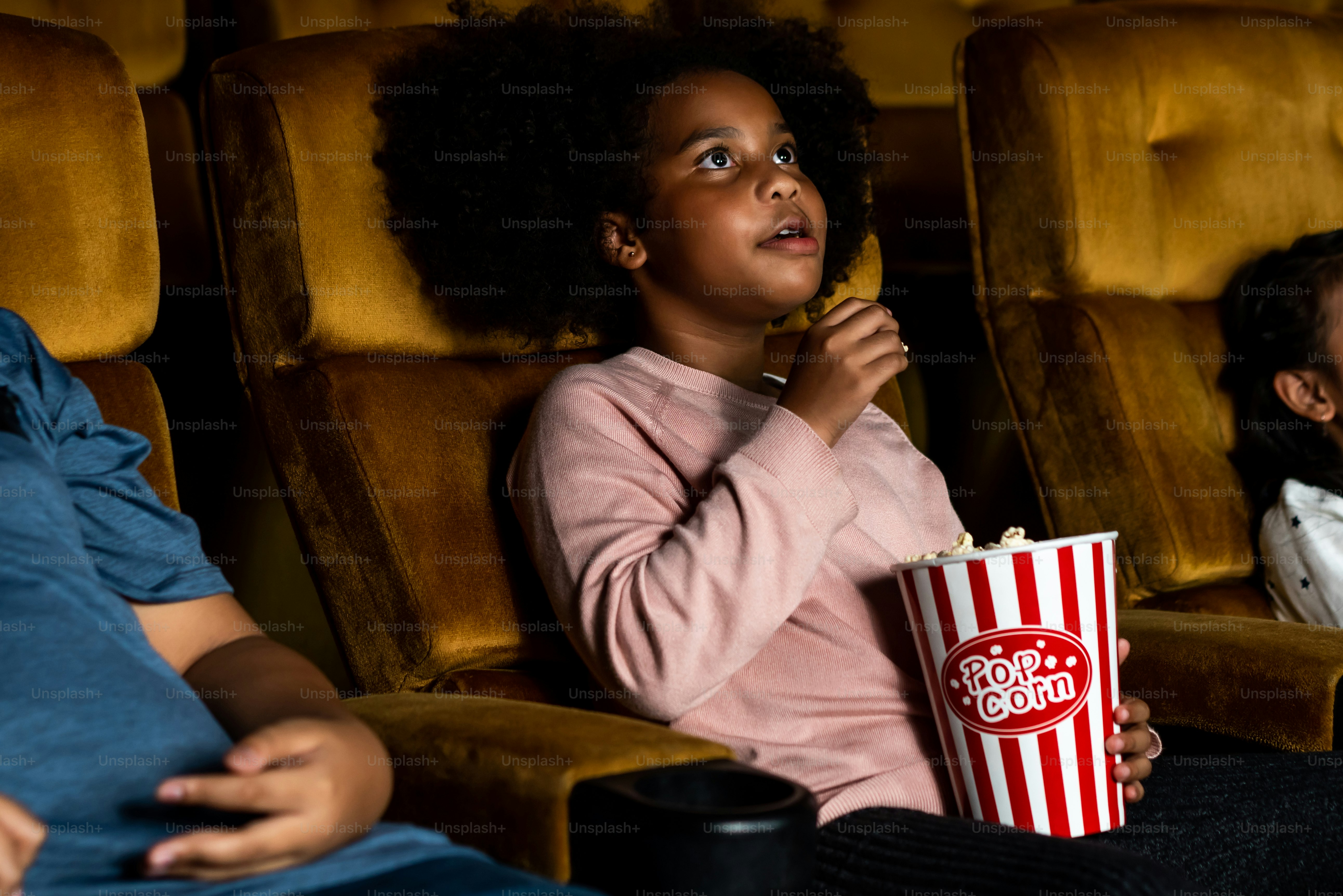 Three children having fun and enjoy watching movie in cinema