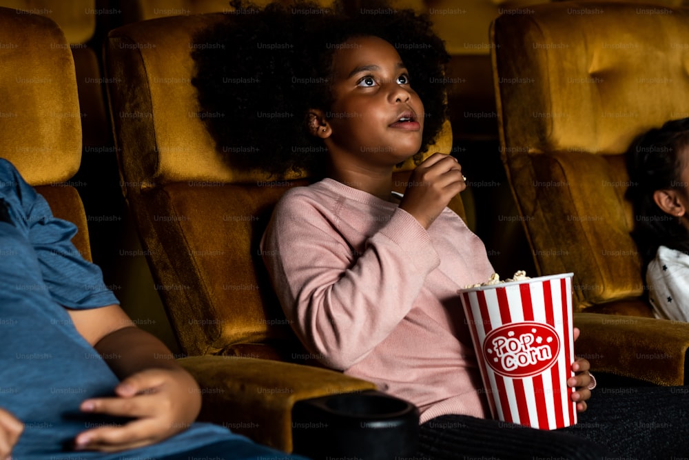 Drei Kinder haben Spaß und genießen es, Filme im Kino zu sehen
