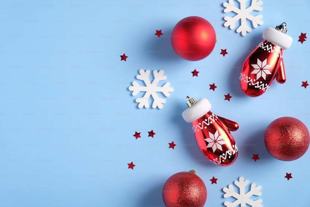 빨간 공과 장갑, 하얀 눈송이, 크리스마스 장식이 있는 블루 크리스마스 배경. 빈티지 크리스마스 플랫 레이 스타일 구성, 평면도.