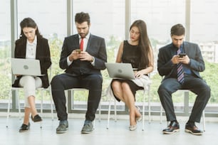 Job seekers and applicants waiting for interview on chairs in office. Job application and recruitment interview qualification concept.