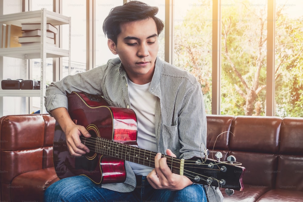 自宅でギターを手にする若いギタリスト。音楽と歌のコンセプト。