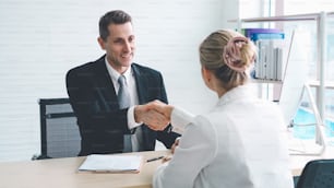 Job seeker and manager handshake in job interview meeting at corporate office. The young interviewee seeking for a professional career job opportunity . Human resources and recruitment concept.