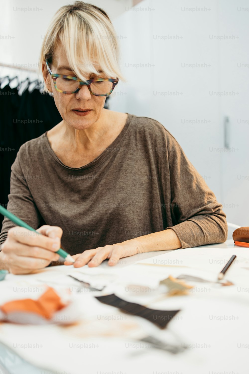 Professionelle weibliche Senior Designerin, die im Modestudio arbeitet. Kreatives Menschenkonzept.