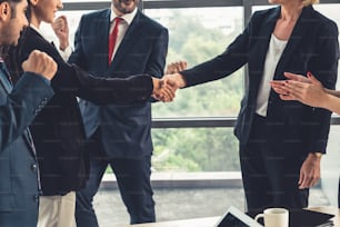 Business people handshake in corporate office showing professional agreement on a financial deal contract.