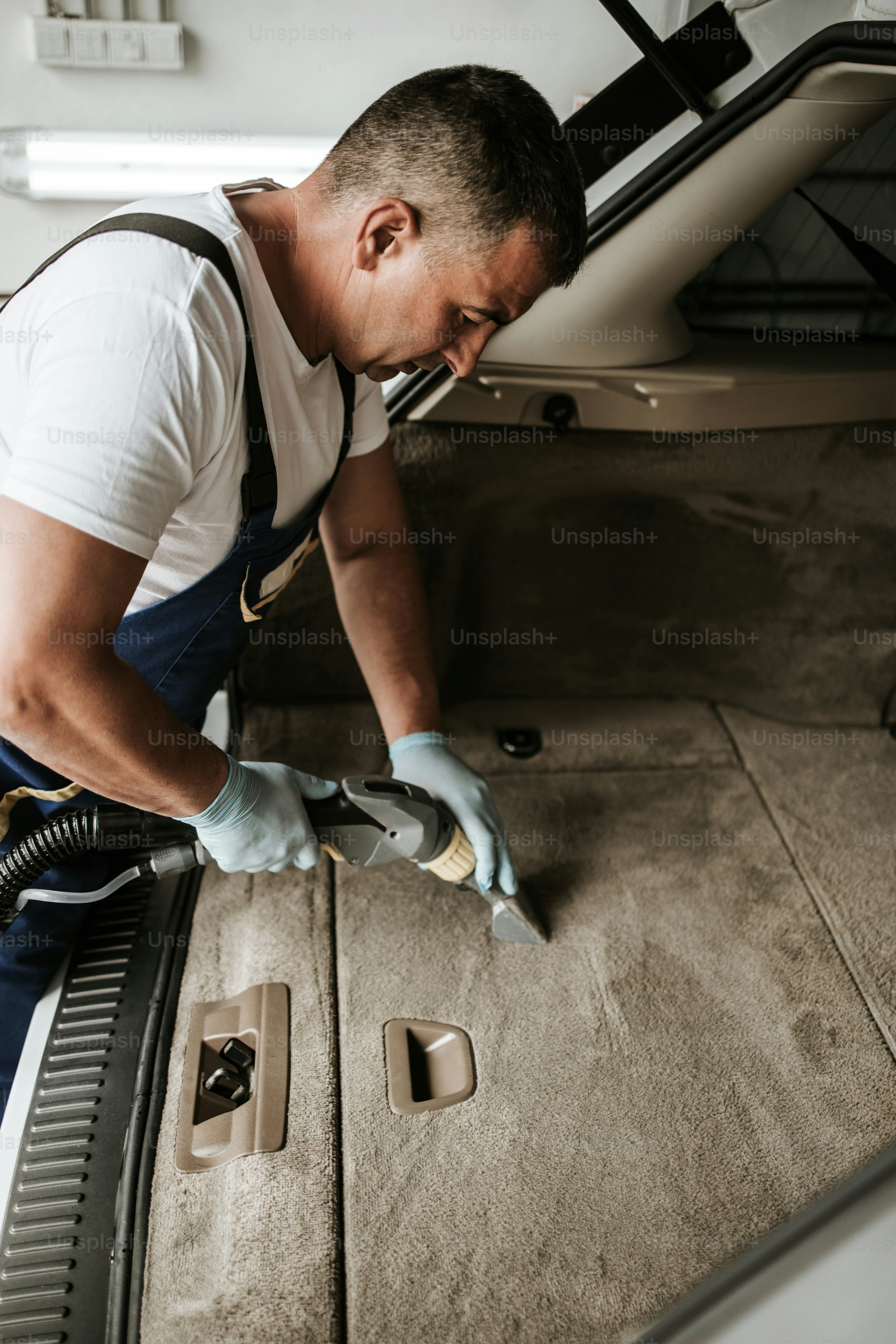 Autowaschdienstmitarbeiter Nassreinigung teures und luxuriöses Fahrzeuginterieur und Sitze