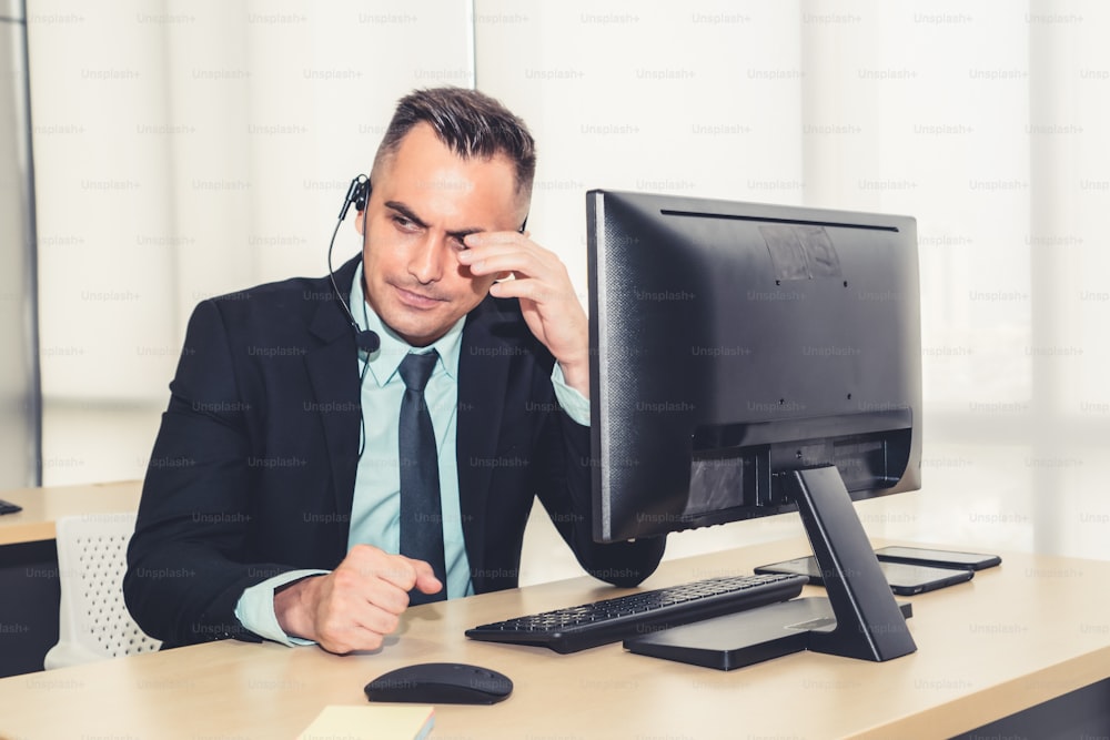 Gli uomini d'affari che indossano l'auricolare si sentono infelici di lavorare in ufficio. Fallimento tristezza negativa emozione concetto di call center, telemarketing e assistenza clienti crisi nell'economia finanziaria verso il basso.