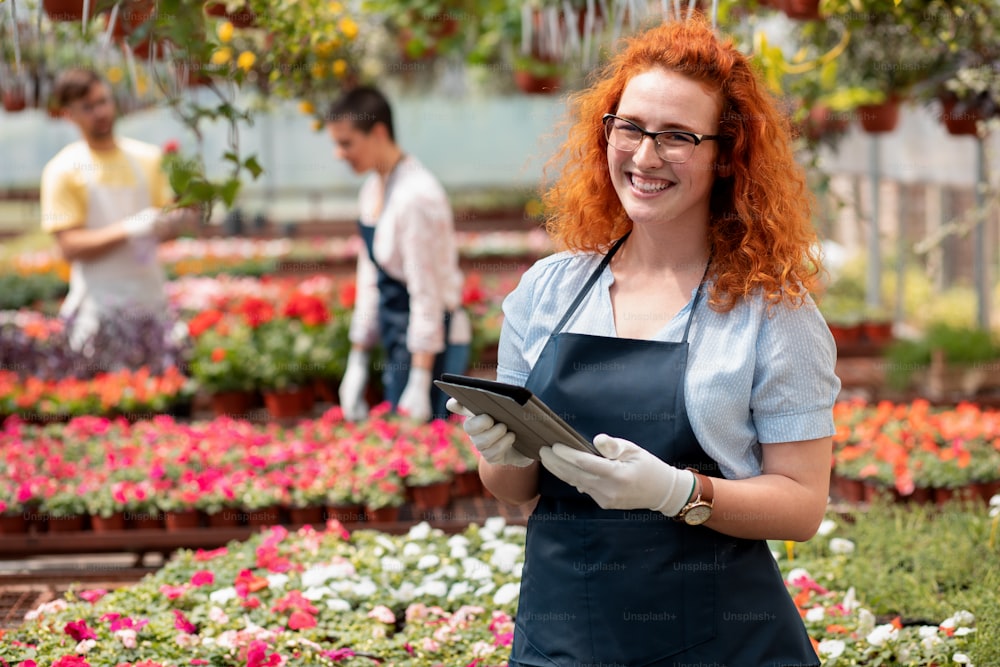 Portrait of female florists working with flowers in a greenhouse.