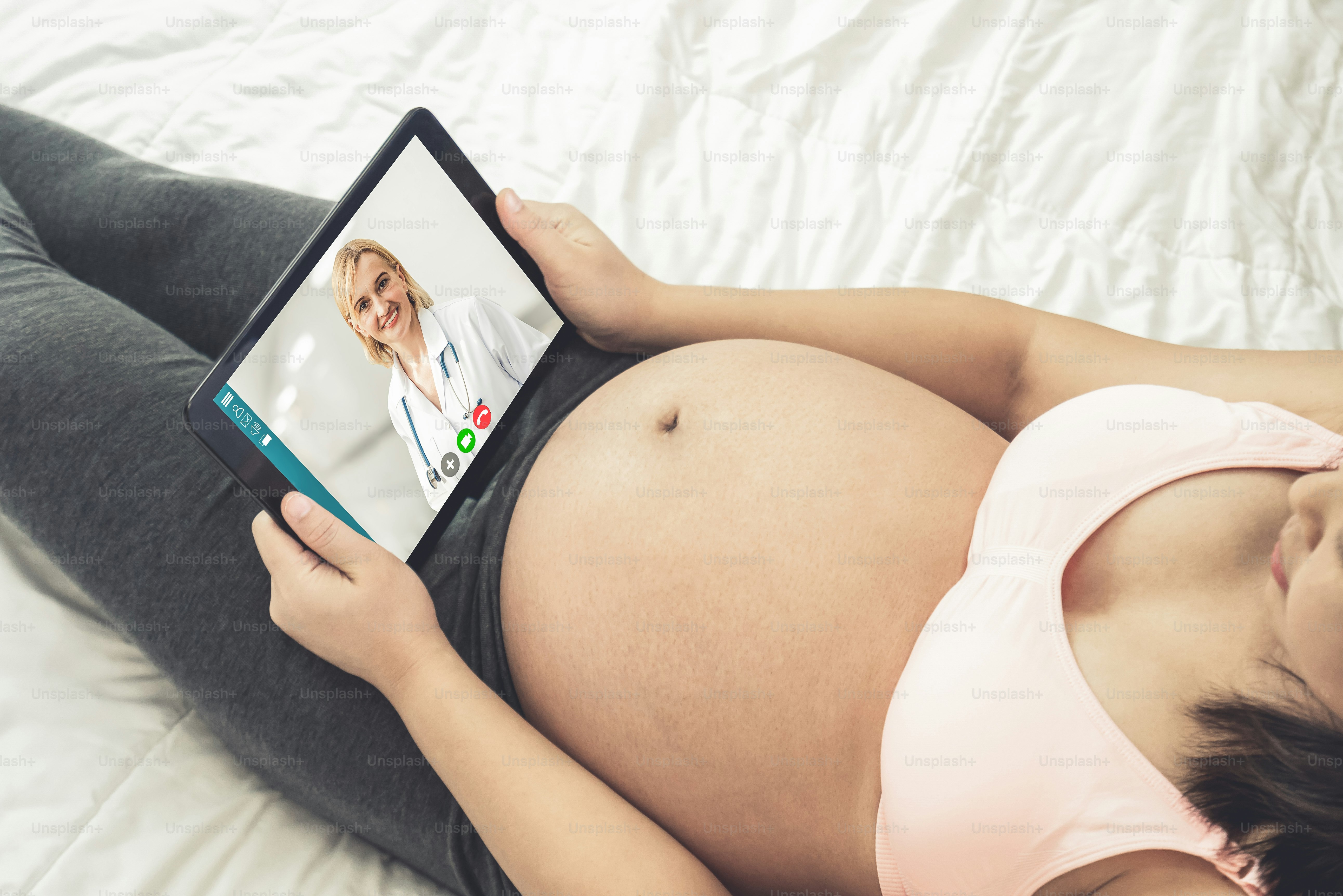 Doctor telemedicine service online video with pregnant woman for prenatal care . Remote doctor healthcare consultant from home using online mobile device connect to internet for live video call .