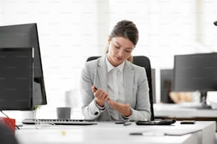 Beautiful businesswoman using lancet pen in office. Young woman checking blood sugar level