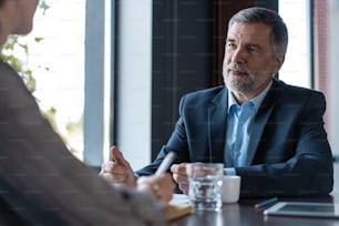 Image of mature businessman interviewing female