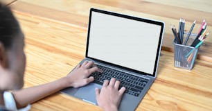 Cropped image of hands is using a computer laptop at the wooden working desk.