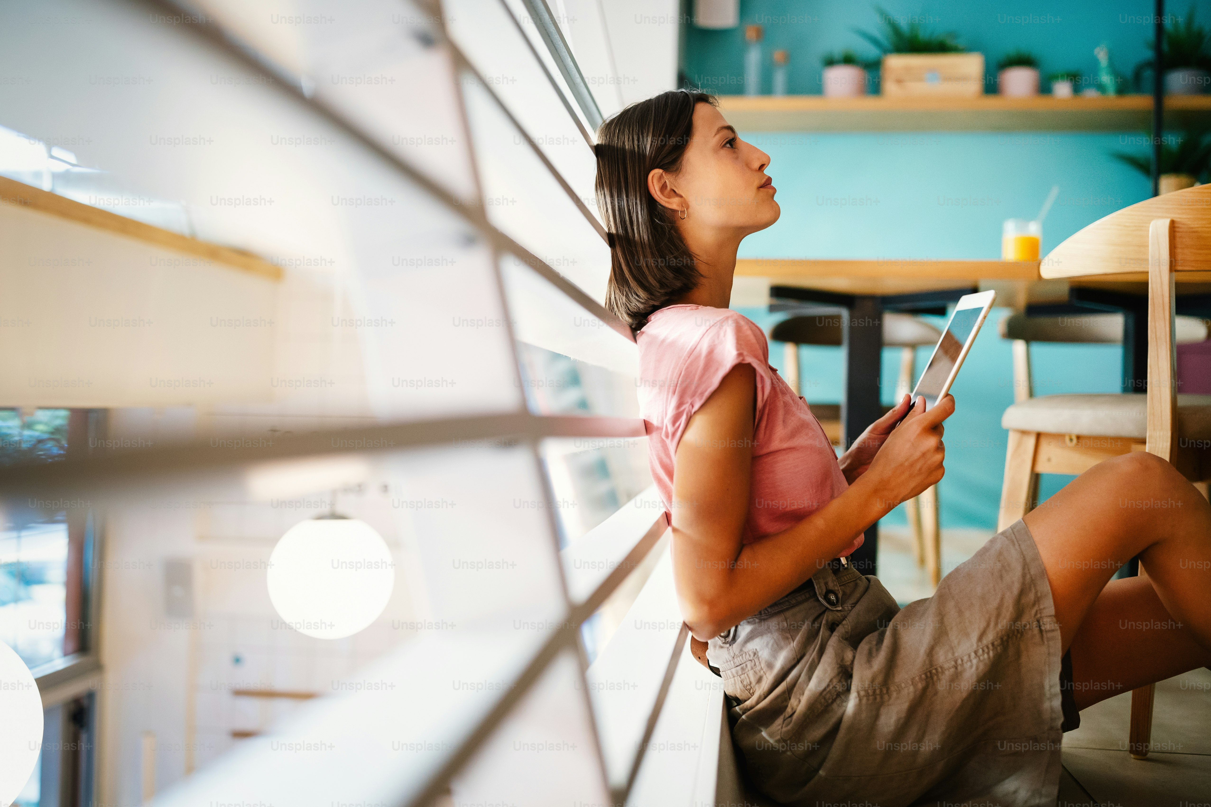 Potret mahasiswa cantik atau wanita bisnis dalam smart casual menggunakan tablet digital