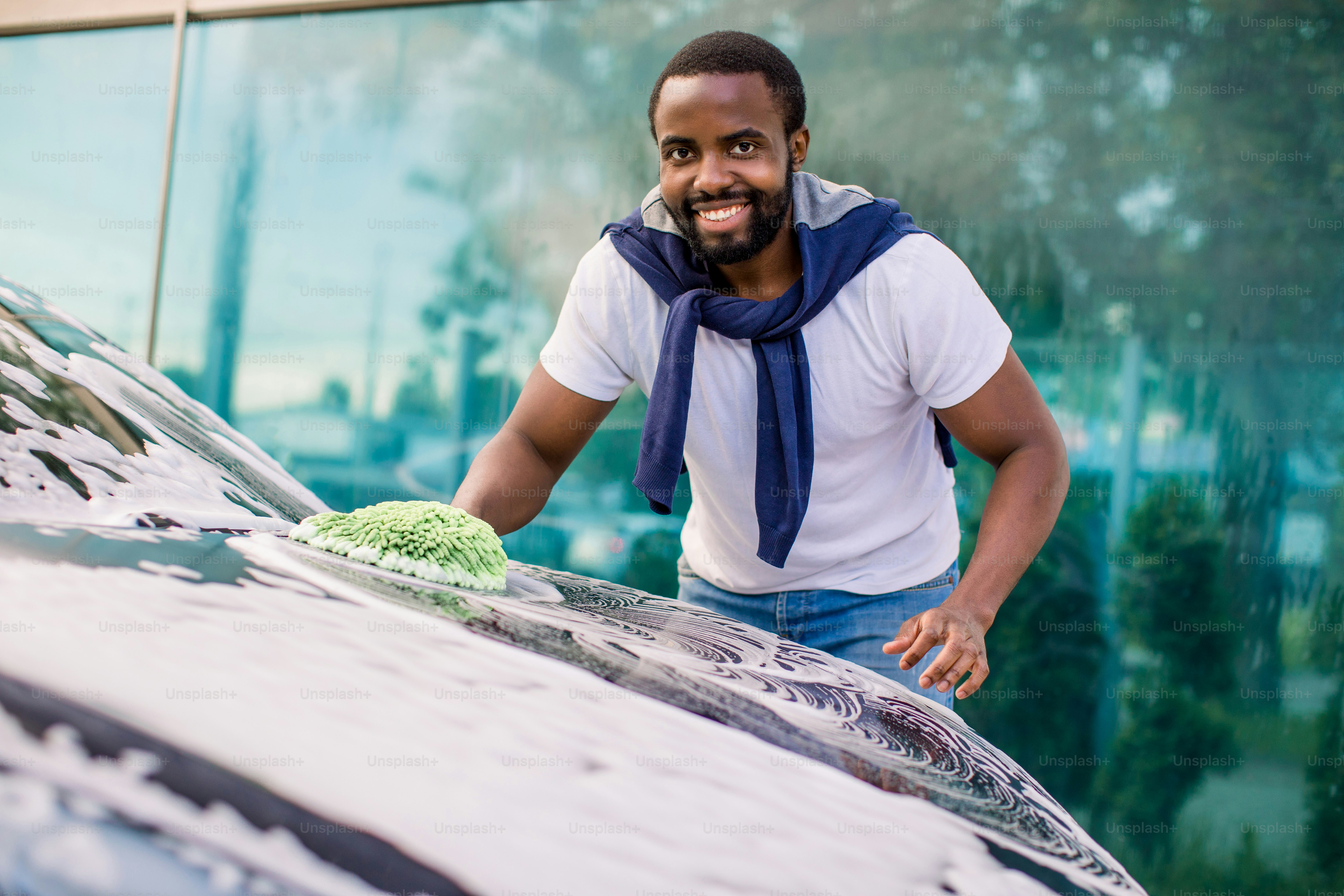 Car washing, outdoor self car wash service concept. Smiling African