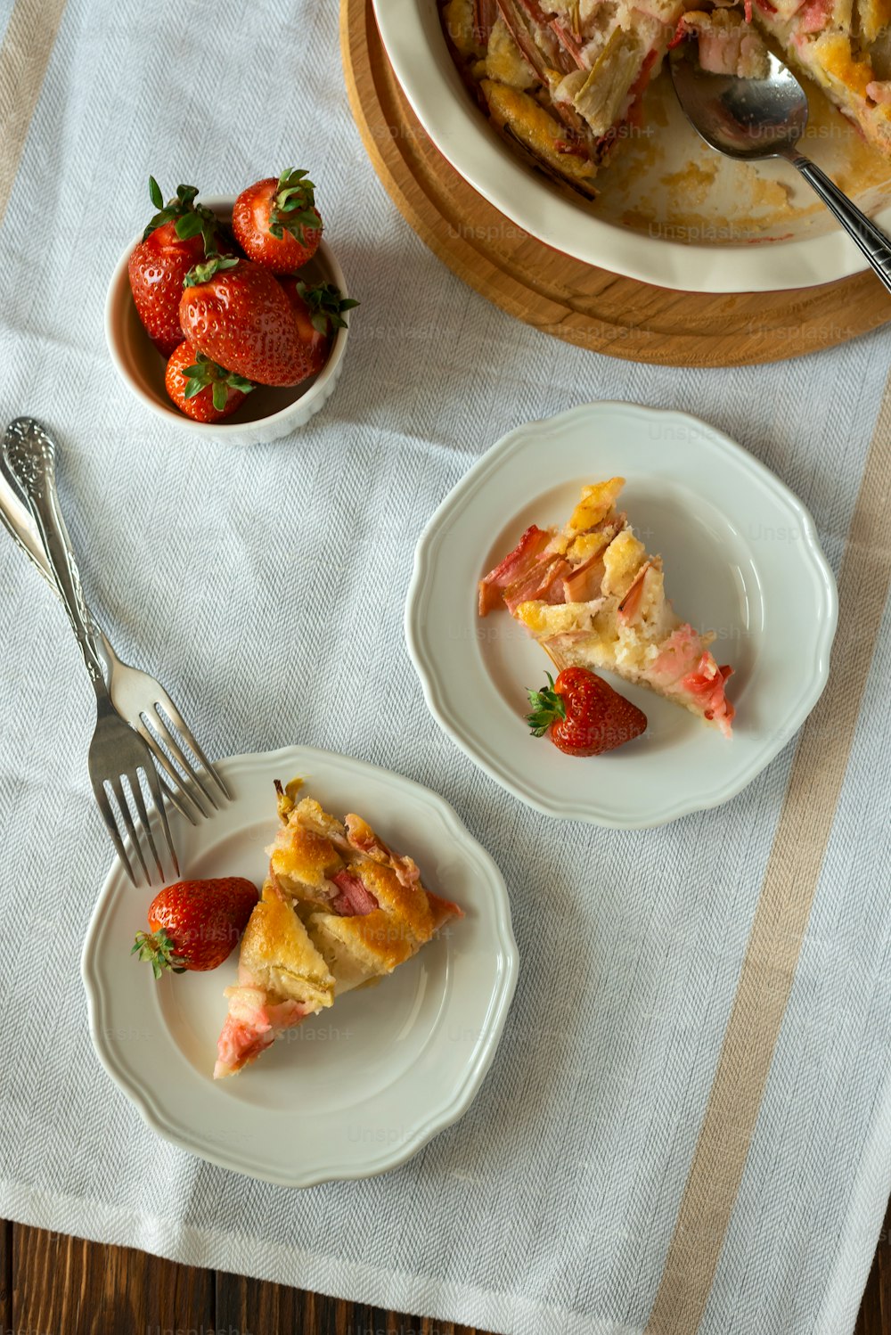 접시에 신선한 딸기와 대황 파이 조각. 여름 음식 먹기. 상위 뷰
