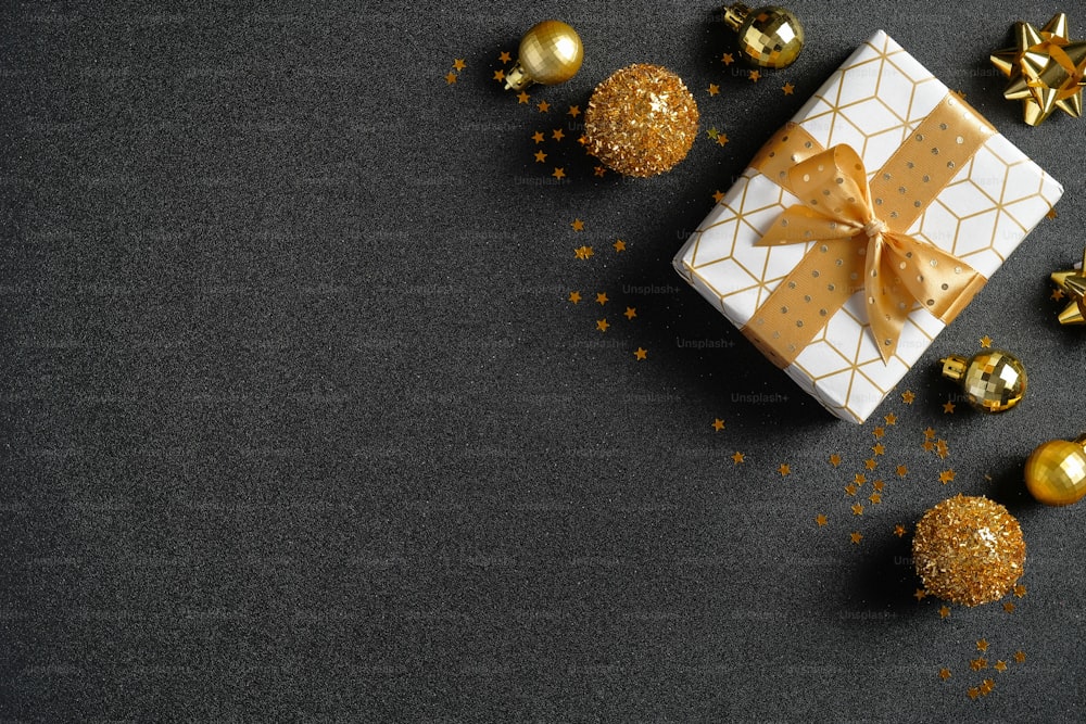 어두운 크리스마스 배경에는 고급 선물 상자, 황금 공 및 장식이 있습니다. 평평한 누워, 평면도, 오버 헤드. 크리스마스 판매 배너 모형, 새해 엽서 템플릿입니다.
