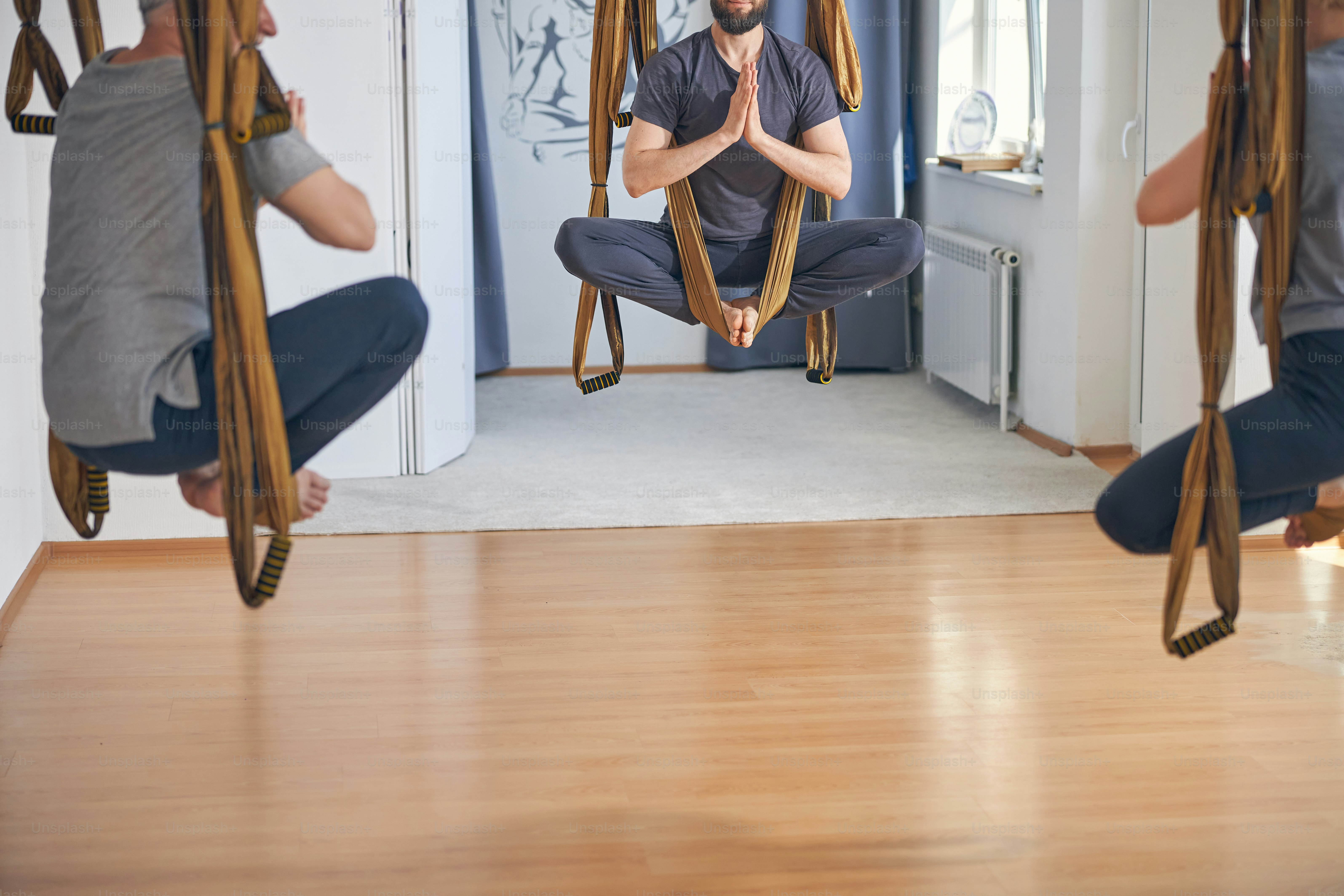 Mature man and his personal trainer doing the seated tree pose on the ...