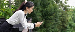 Side view of female office worker using smartphone while relaxing at  terrace