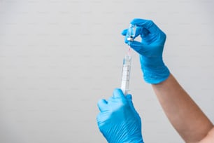 Flacon de vaccin COVID-19 contre le virus Corona et seringue d’injection dans le concept de mains de scientifique.