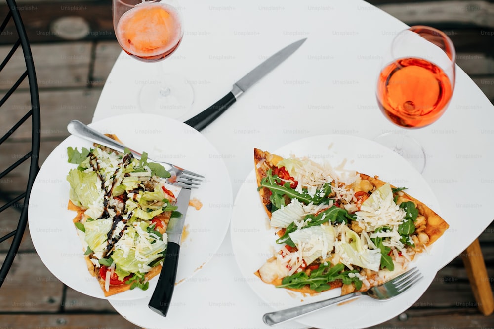 Pizza caseira e bebida de aperol na mesa branca moderna no terraço, jantar para dois. Deliciosa pizza e coquetéis para a celebração em casa ou café. Férias de verão e resort.