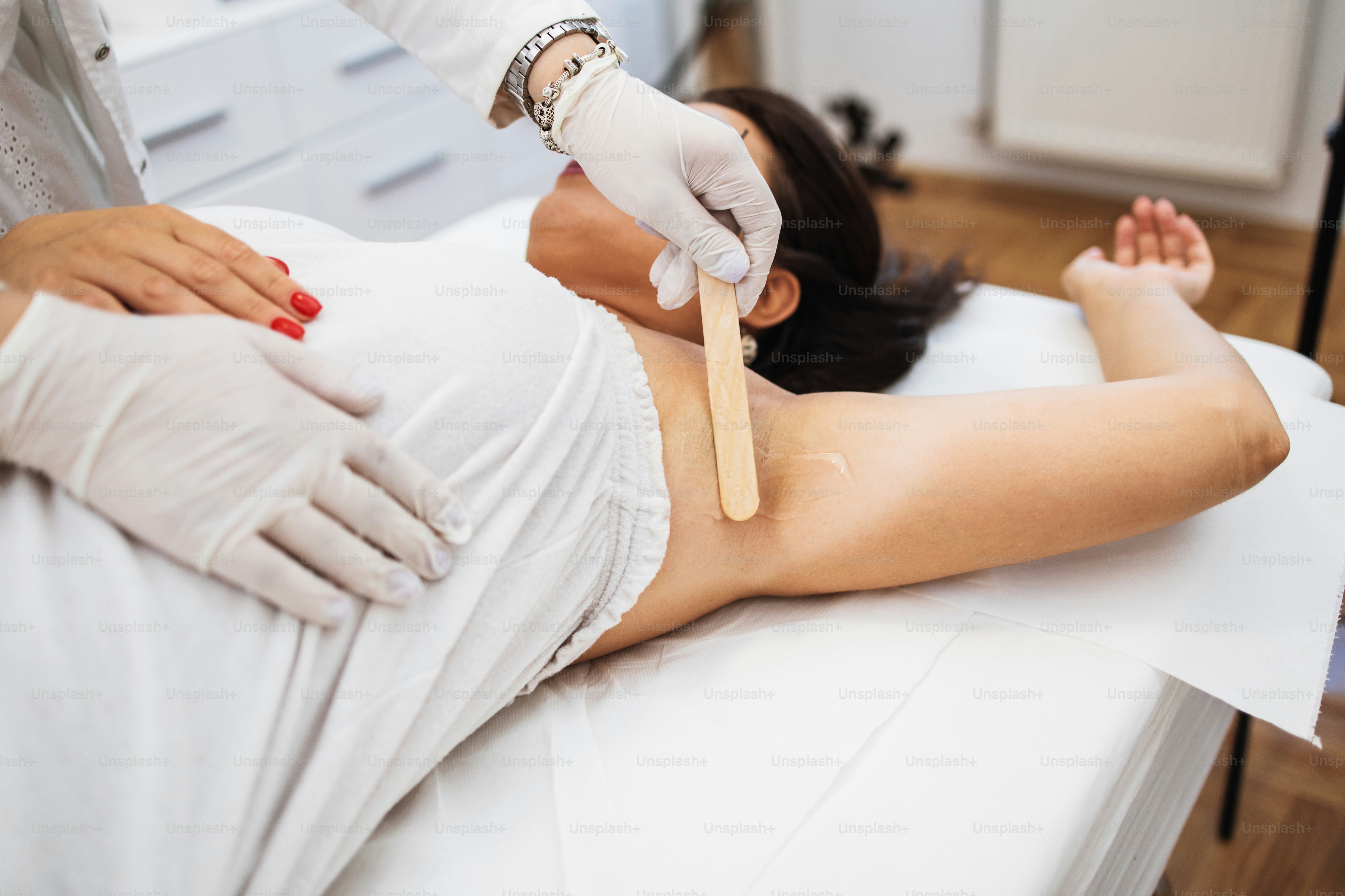 Giovane bella donna che riceve il trattamento di epilazione della pelle delle gambe e del corpo. Moderno concetto di cura del corpo e cosmetica.