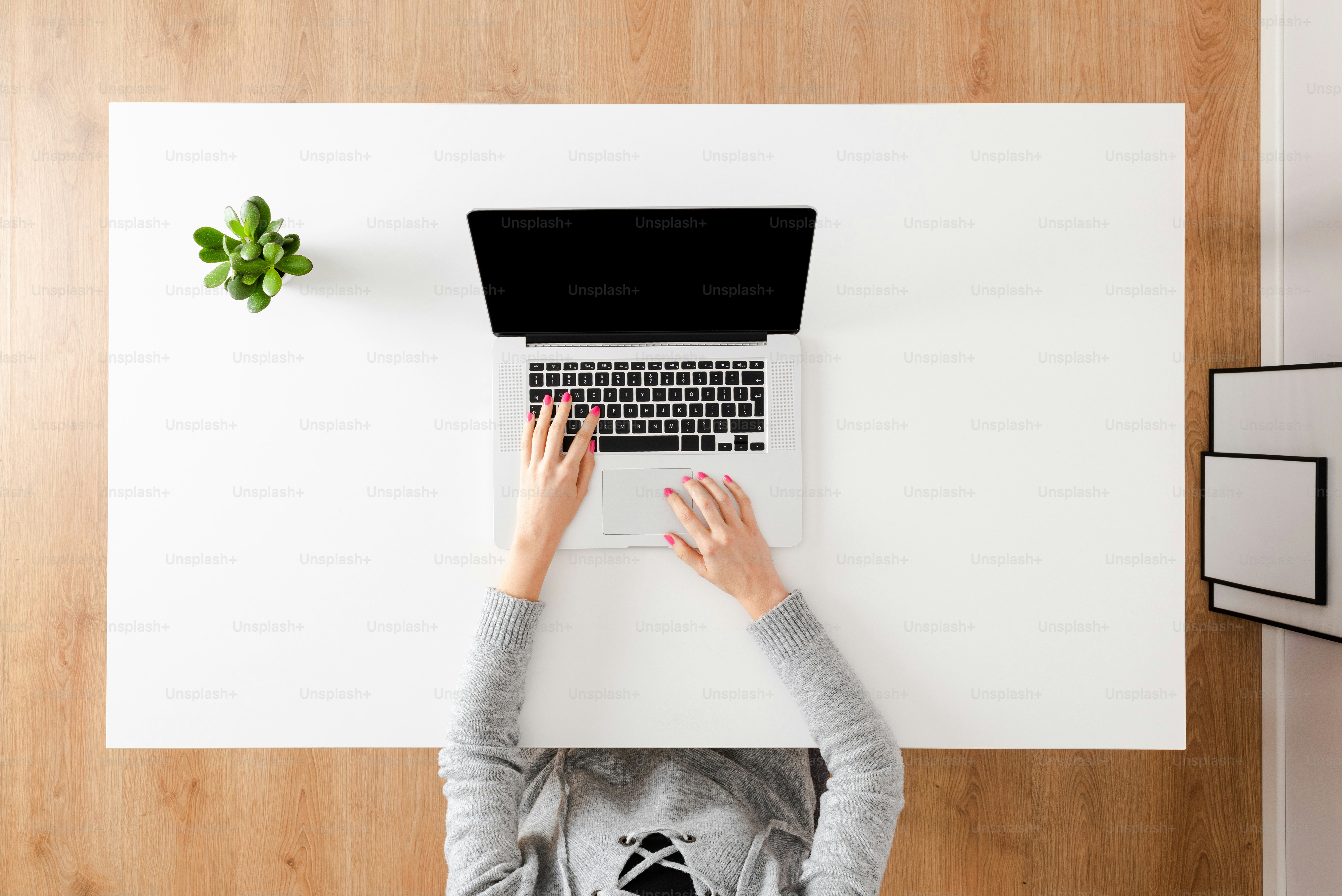 Overhead shot of woman’s hands woking on laptop