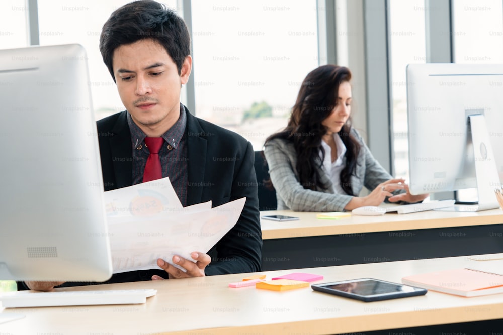 Business people working at table in modern office room while analyzing financial data report .