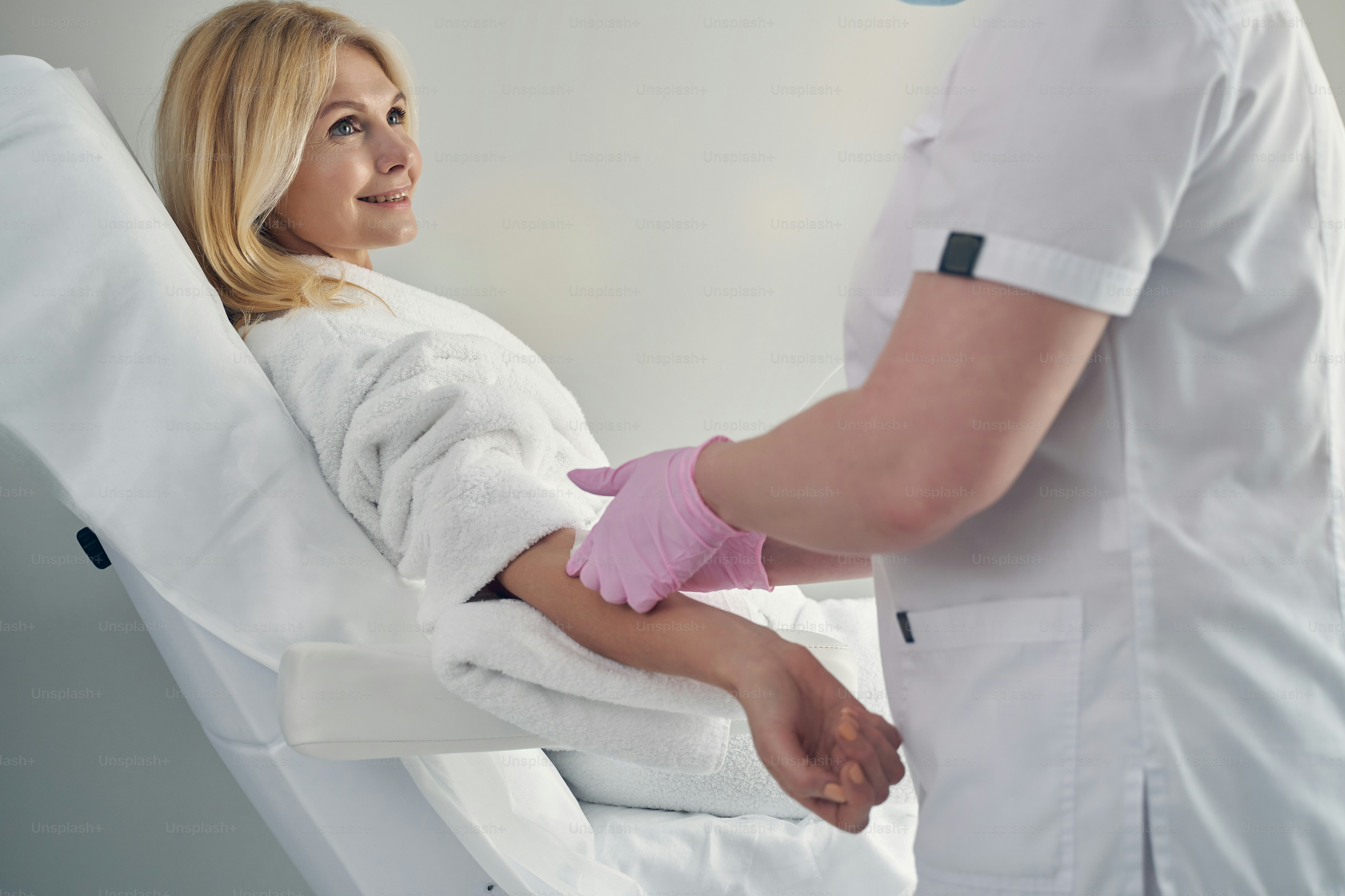 Lovely mature female getting vitamin therapy with a help of intravenous cannulation