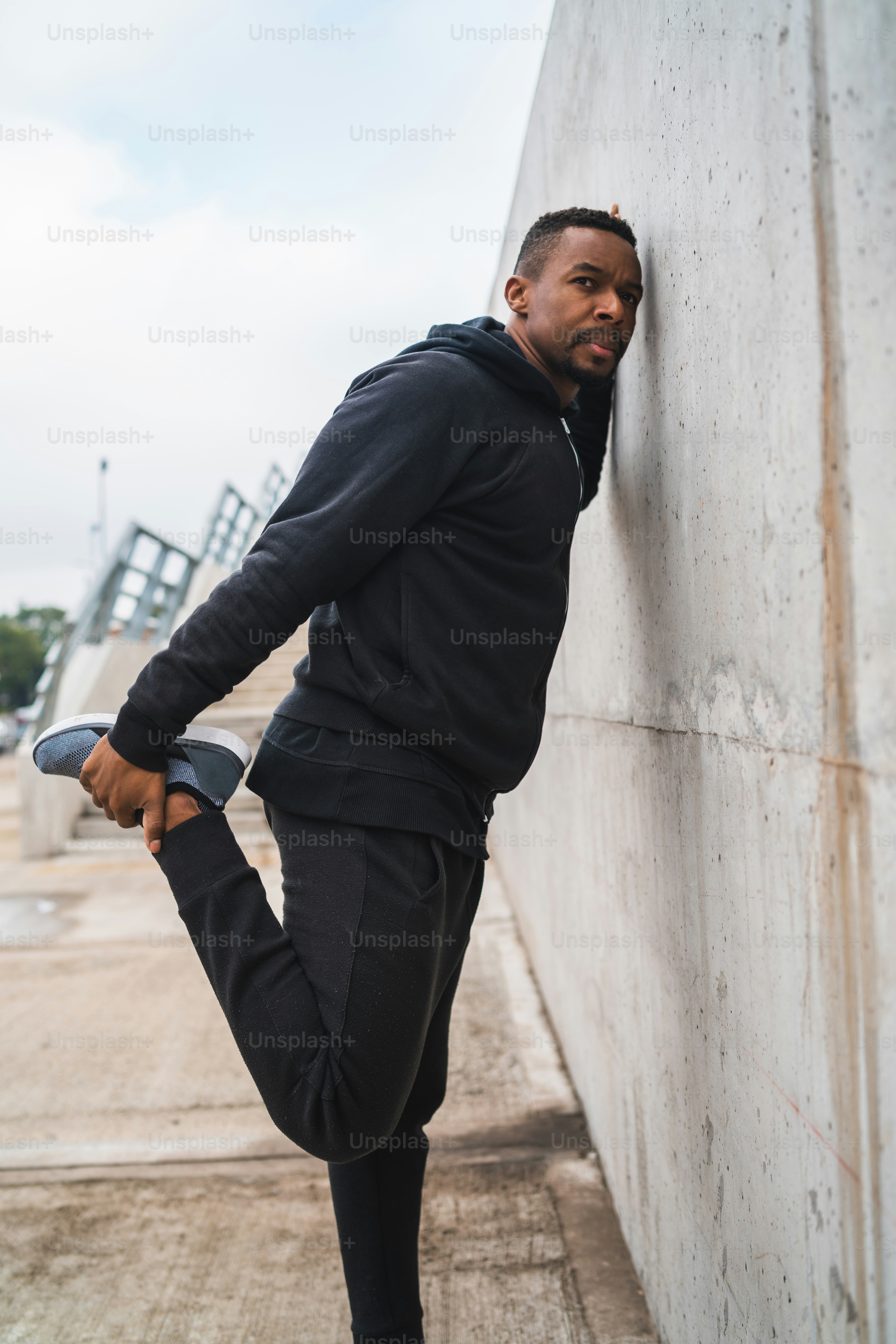 Portrait of an athletic man stretching legs before exercise outdoors. Sport and healthy lifestyle.