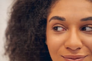 Lovely optimistic Afro American woman glancing sideways and expressing calmness