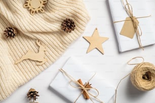 Vintage wooden Christmas decorations and gift boxes on white background. Christmas eco decor concept. Flat lay, top view.