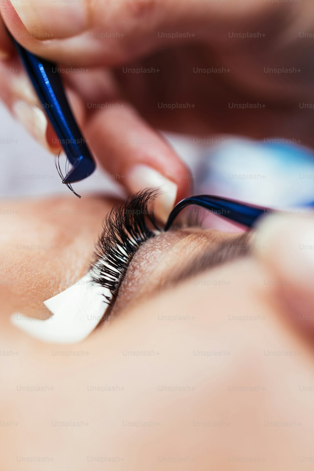 Beautiful middle age woman at eyelash extension procedure. Cosmetics and body care close up shot.