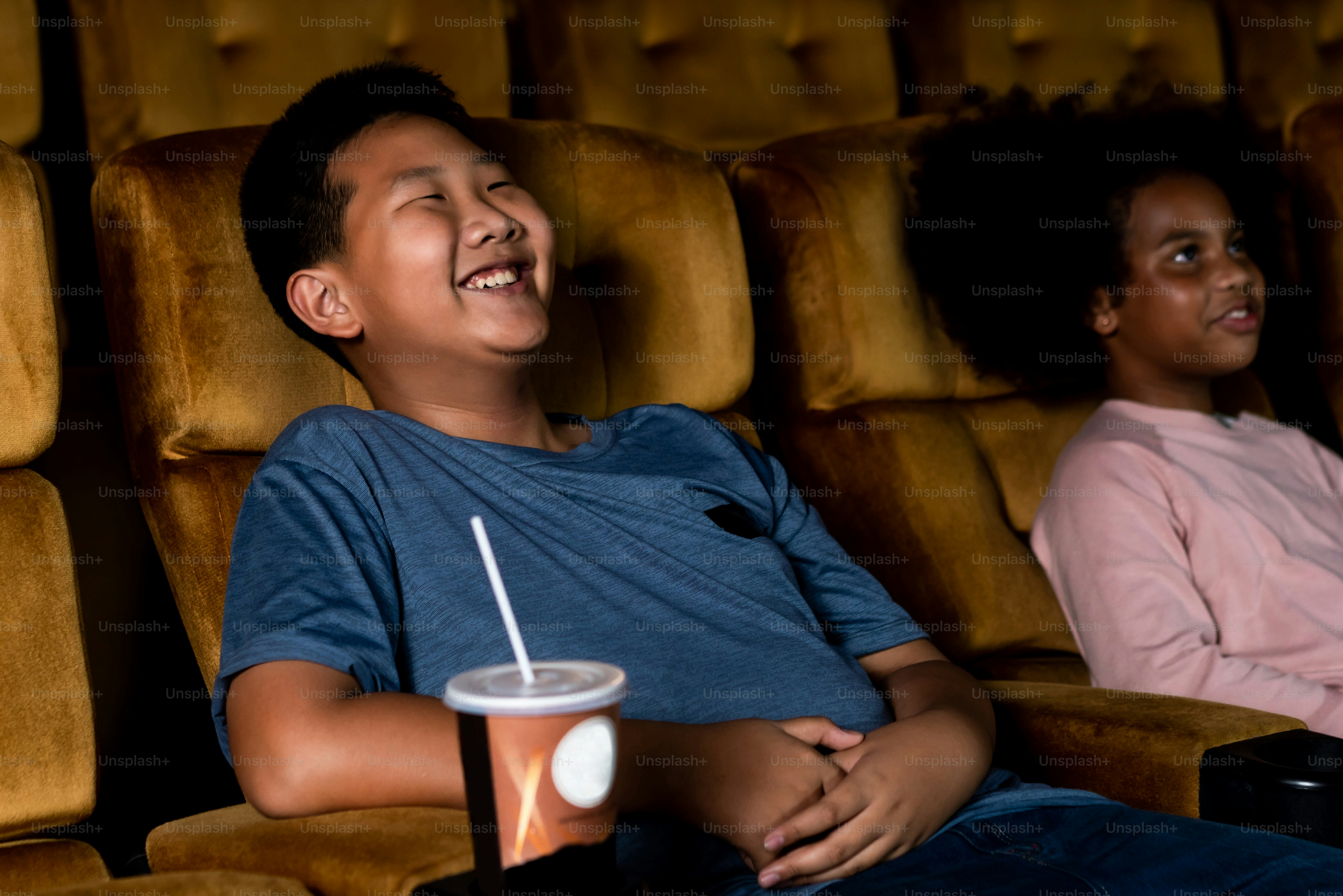Three children having fun and enjoy watching movie in cinema