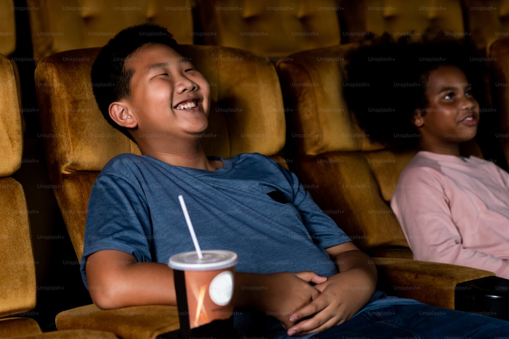 Tre bambini che si divertono e si divertono a guardare film nel cinema