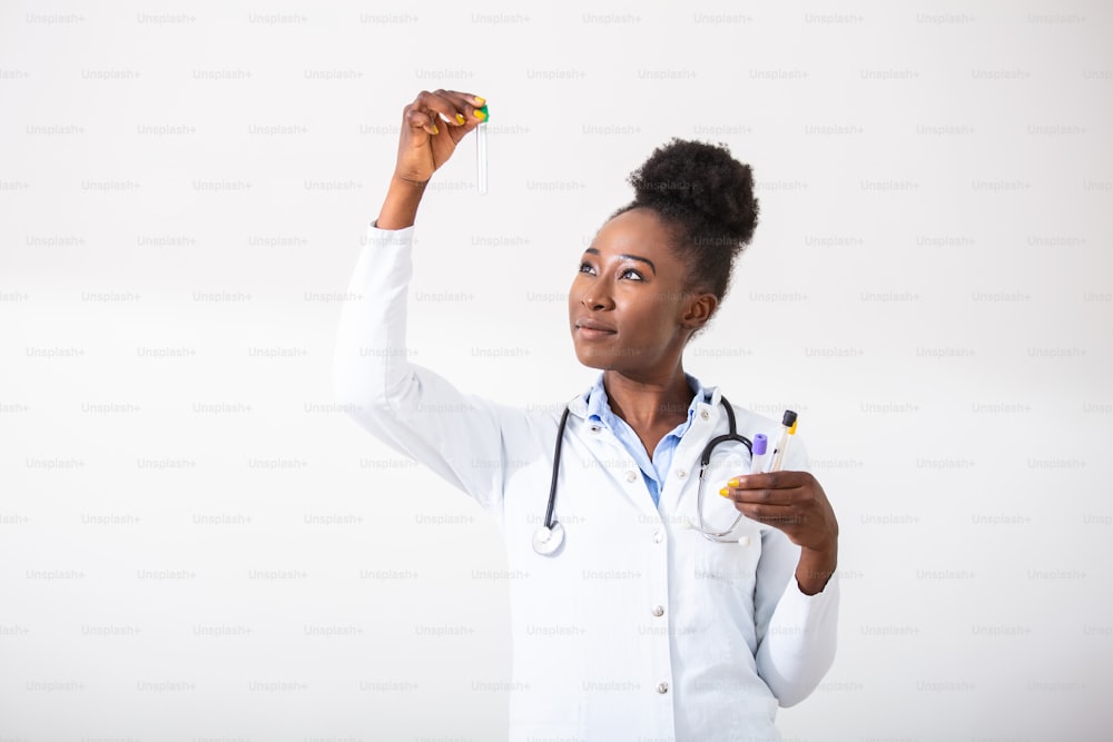 Doctora en bata blanca sosteniendo tubos de análisis de sangre en las manos mientras trabaja en un laboratorio moderno. Profesional de ciencias de la vida femenina con cubeta de vidrio. Concepto de salud y biotecnología.
