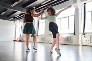 Foto completa de duas amigas dançando dança moderna