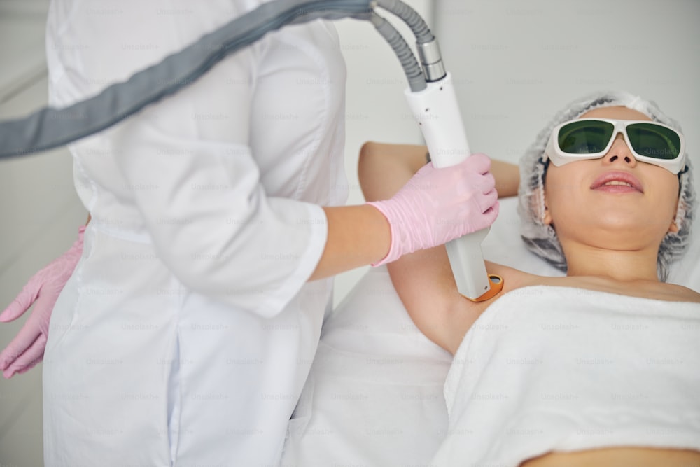 Young Caucasian female patient undergoing a laser armpit hair removal  treatment in a beauty parlor photo – Hair Image on Unsplash