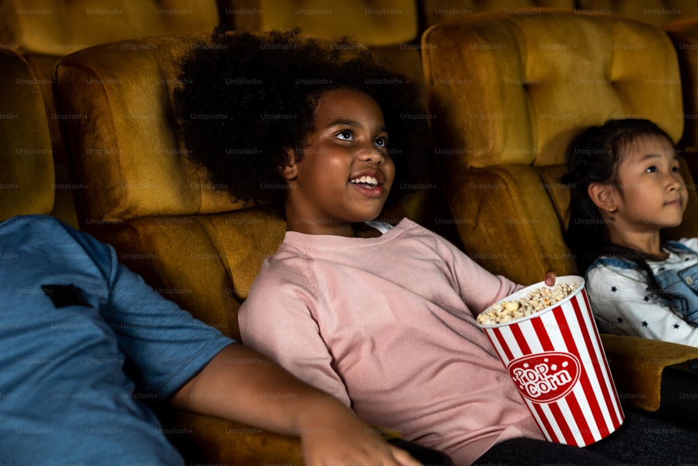 Tre bambini che si divertono e si divertono a guardare film nel cinema