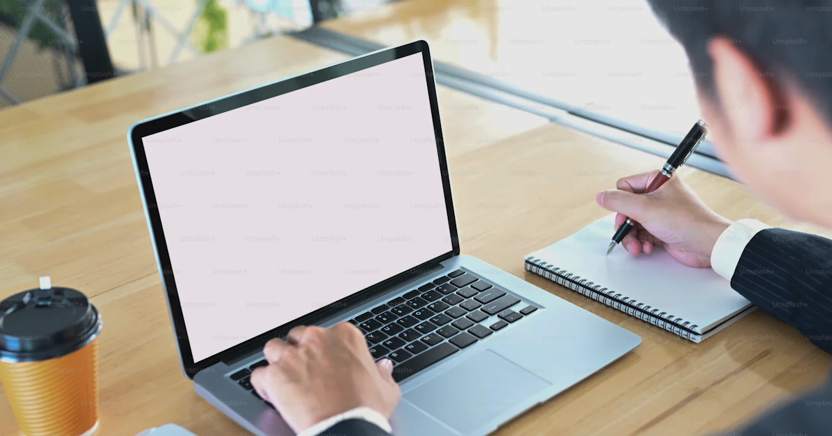 Unsplash Main Using Computer Businessman is using a computer laptop and taking at the wooden working ...
