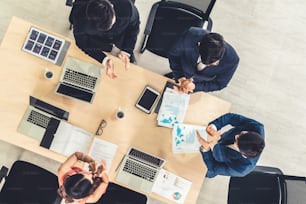 Los empresarios exitosos celebran juntos con alegría en la mesa de la oficina tomada desde la vista superior. Jóvenes empresarios y empresarias expresan alegre victoria mostrando éxito por el trabajo en equipo.